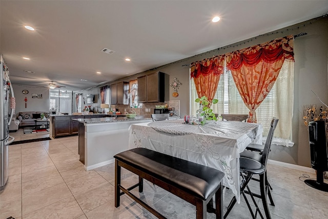 tiled dining space with ceiling fan