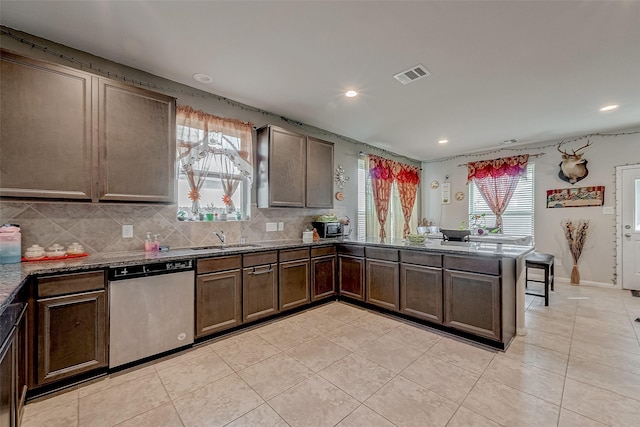 kitchen with sink, tasteful backsplash, light tile patterned floors, dishwasher, and kitchen peninsula