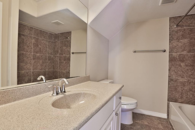 full bathroom with tile patterned floors, toilet, tiled shower / bath, vaulted ceiling, and vanity