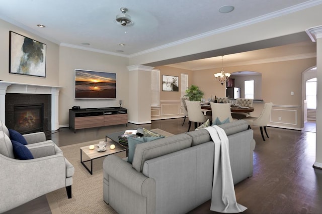 living room featuring an inviting chandelier, crown molding, and wood-type flooring