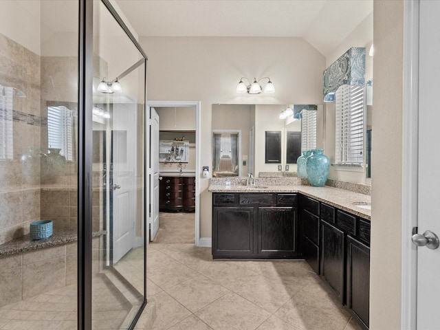 bathroom with vanity, vaulted ceiling, tile patterned floors, and walk in shower