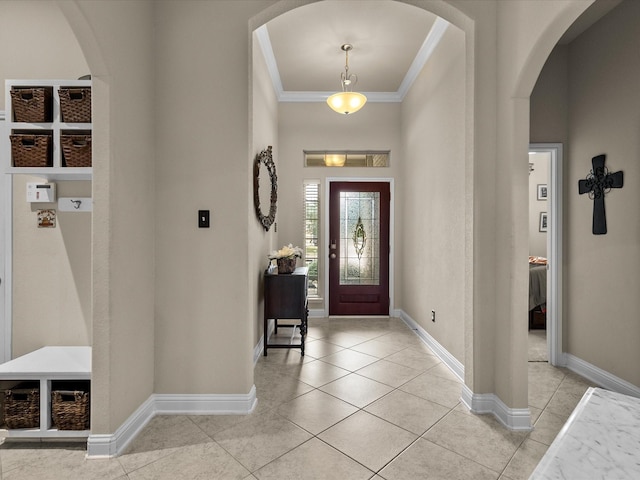 entryway with light tile patterned flooring and ornamental molding