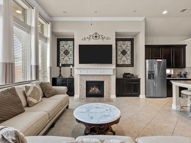 tiled living room with crown molding and a tile fireplace