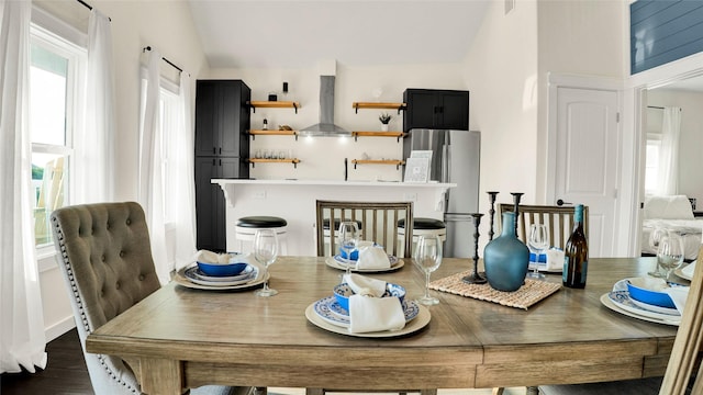 dining area featuring vaulted ceiling and dark hardwood / wood-style flooring