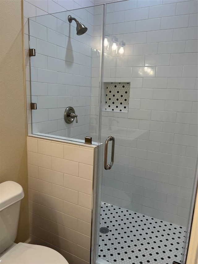 bathroom featuring an enclosed shower and toilet