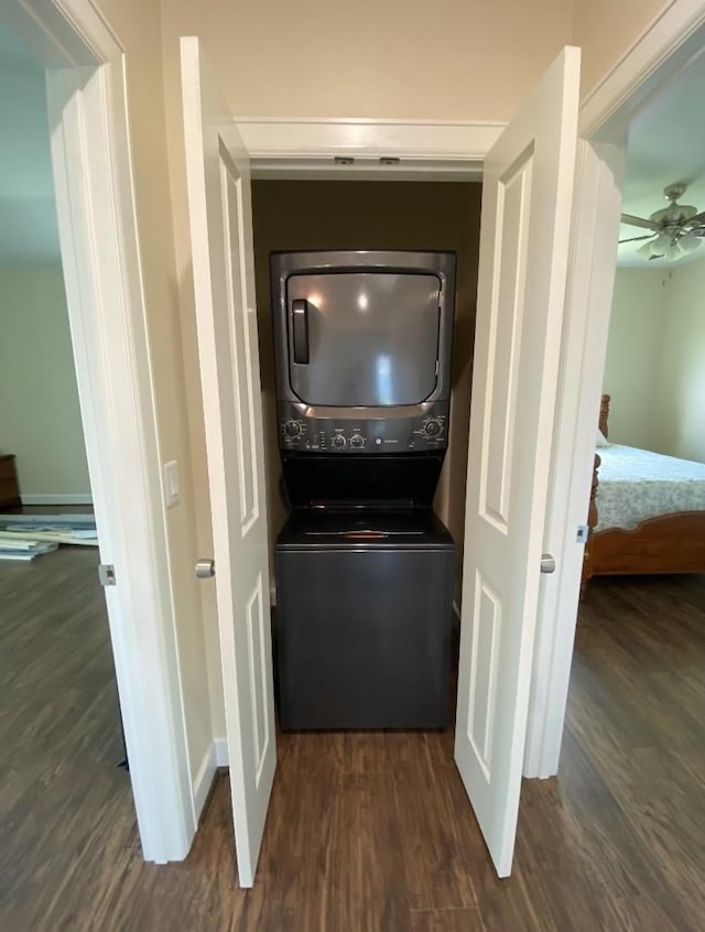 washroom with dark hardwood / wood-style flooring, stacked washer and dryer, and ceiling fan