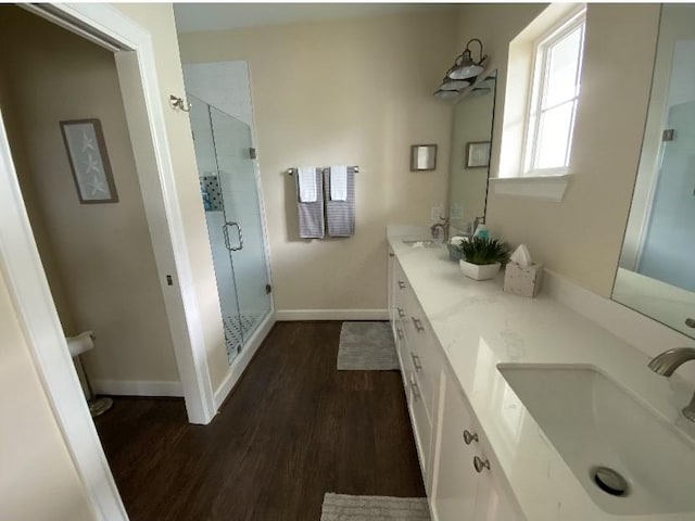 bathroom with hardwood / wood-style flooring, vanity, and a shower with shower door