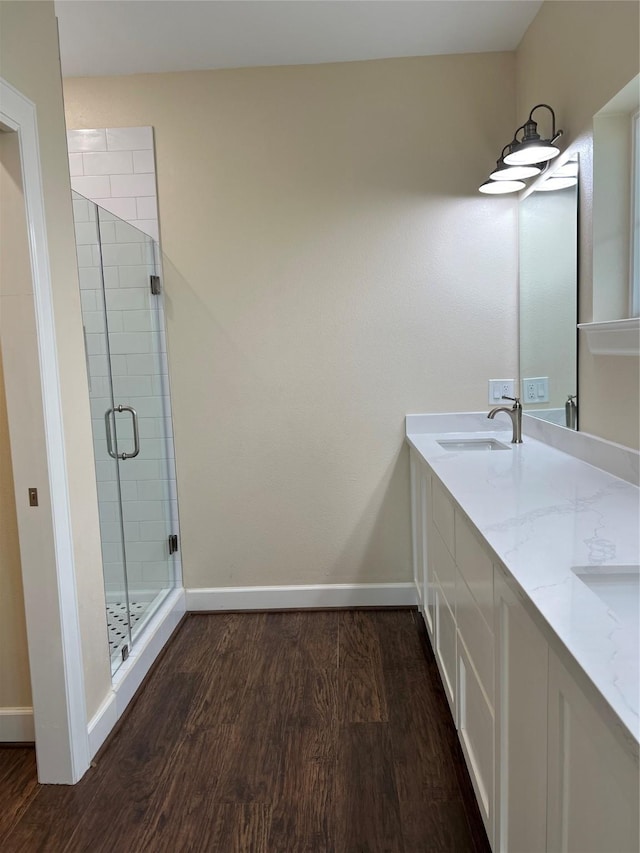 bathroom featuring hardwood / wood-style flooring, vanity, and walk in shower