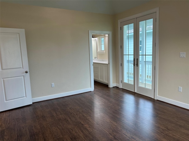 spare room with french doors, dark hardwood / wood-style floors, and a wealth of natural light