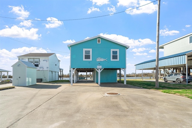 view of front facade featuring a carport and a storage unit