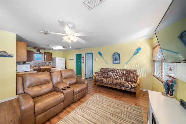 living room with light hardwood / wood-style floors and ceiling fan