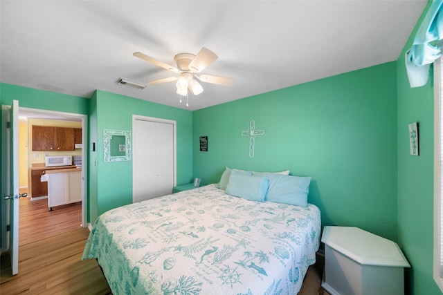 bedroom with a closet, ceiling fan, and light hardwood / wood-style flooring