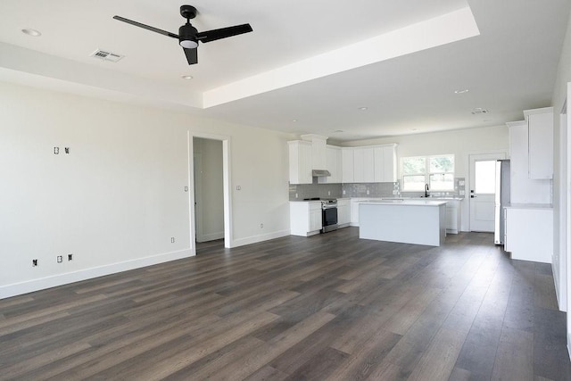 unfurnished living room with ceiling fan, dark hardwood / wood-style flooring, and sink