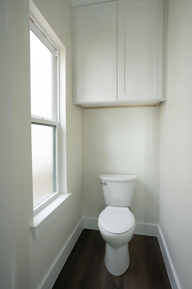 bathroom with wood-type flooring, plenty of natural light, and toilet