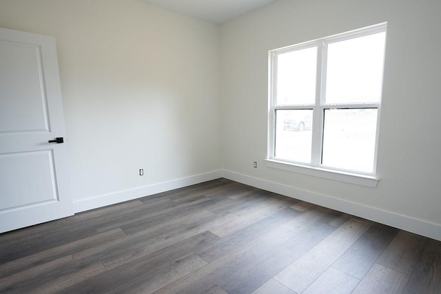 unfurnished room with dark wood-type flooring