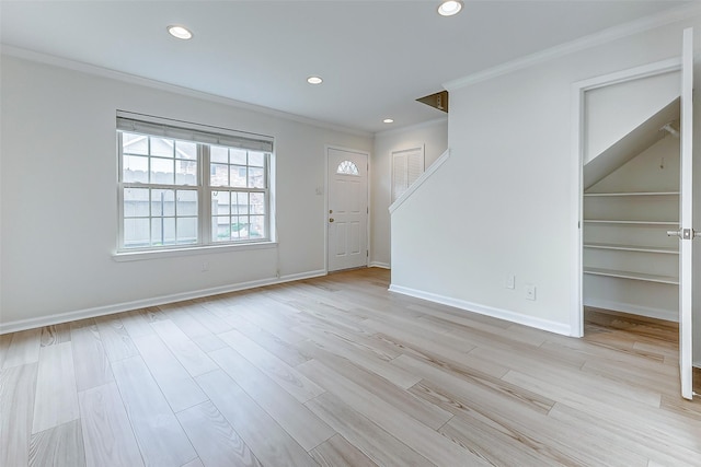 foyer entrance with crown molding and light wood-type flooring