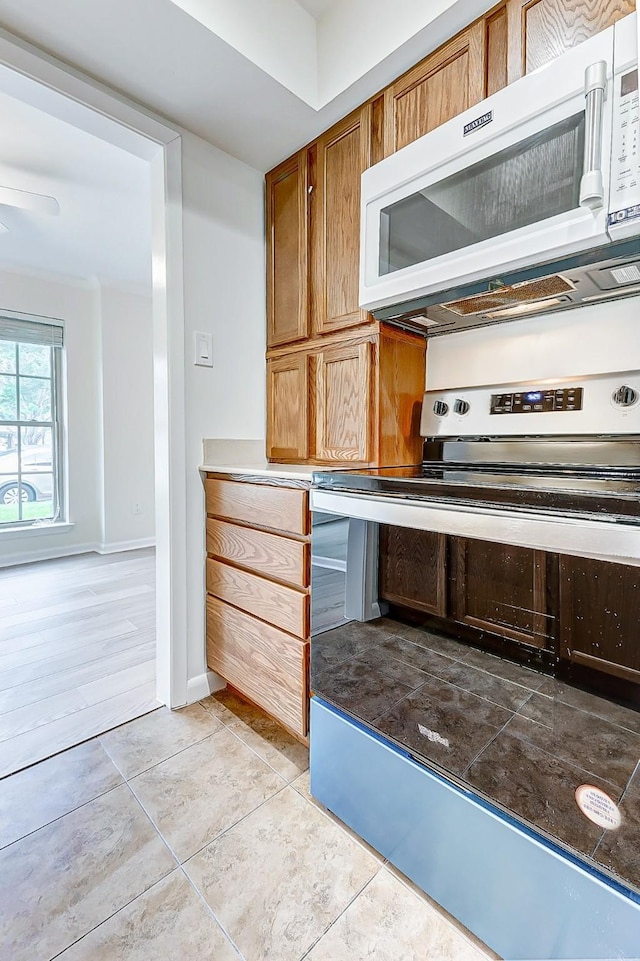 kitchen with light tile patterned flooring and stainless steel electric range