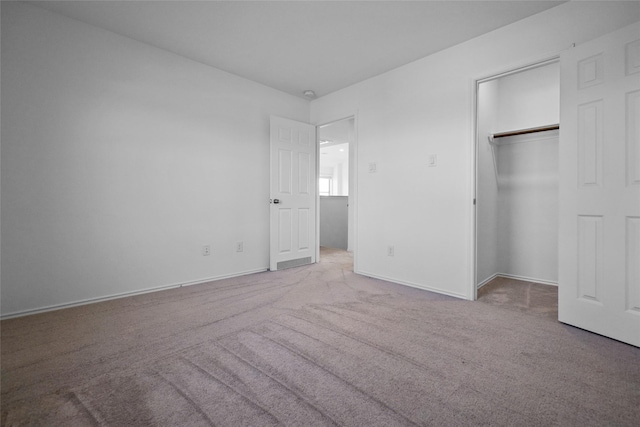 unfurnished bedroom with light carpet and a closet