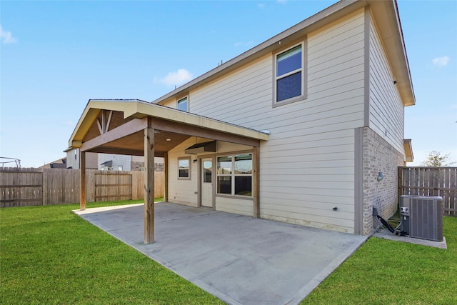 rear view of house featuring central AC, a yard, and a patio area