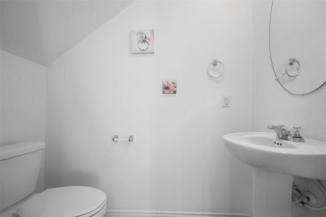 bathroom featuring vaulted ceiling, sink, and toilet