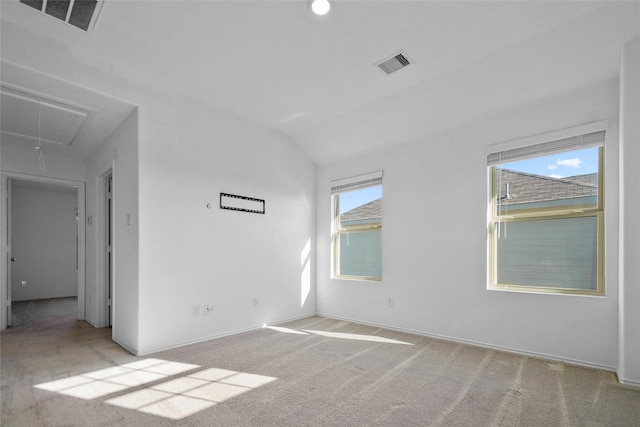 spare room with light carpet, a wealth of natural light, and vaulted ceiling