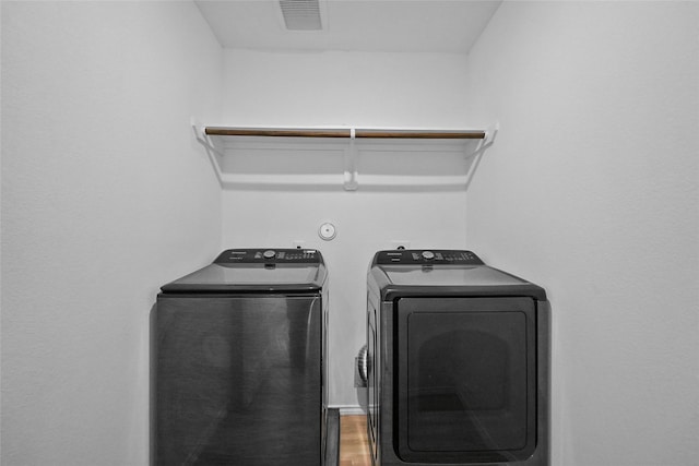 laundry area with wood-type flooring and washer and dryer