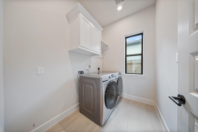 clothes washing area featuring cabinets and separate washer and dryer