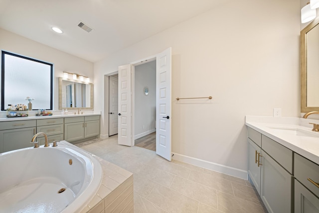 bathroom with vanity, a relaxing tiled tub, and tile patterned floors