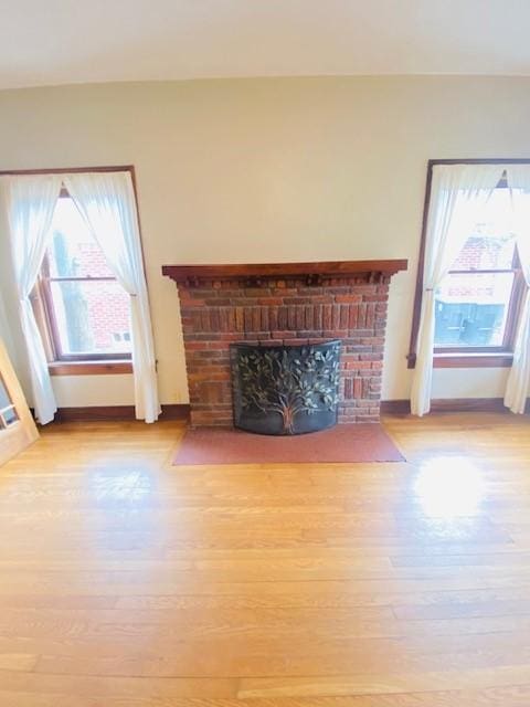 unfurnished living room with a fireplace and light wood-type flooring