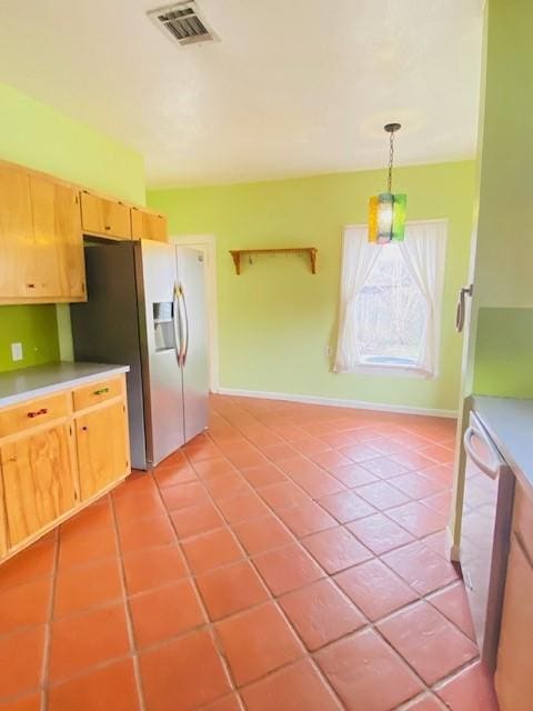 kitchen featuring pendant lighting, light tile patterned floors, stainless steel fridge, and dishwasher