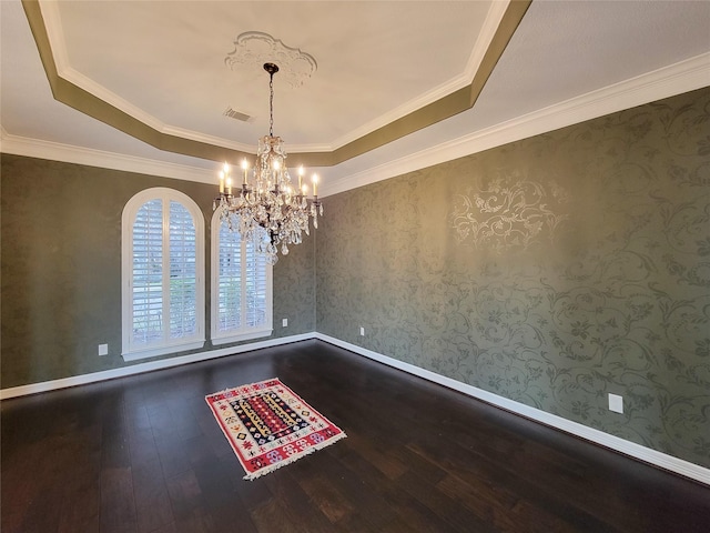 unfurnished room featuring a notable chandelier, a tray ceiling, and hardwood / wood-style flooring