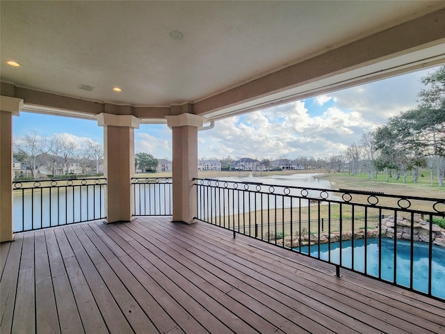 deck with a fenced in pool and a water view