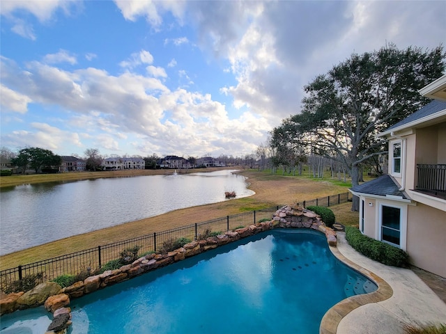 view of swimming pool with a lawn and a water view