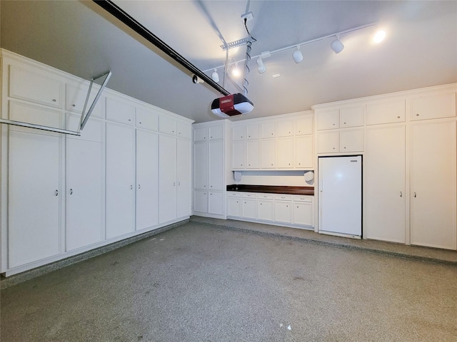 garage featuring a garage door opener and white refrigerator