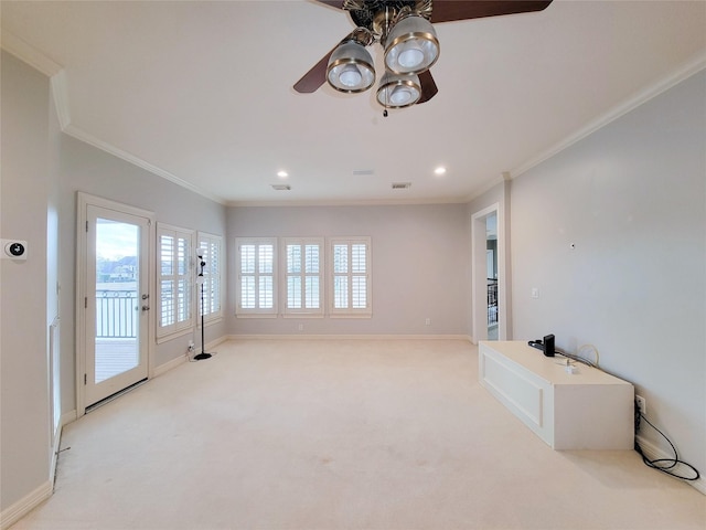 unfurnished living room with ornamental molding, light carpet, and ceiling fan