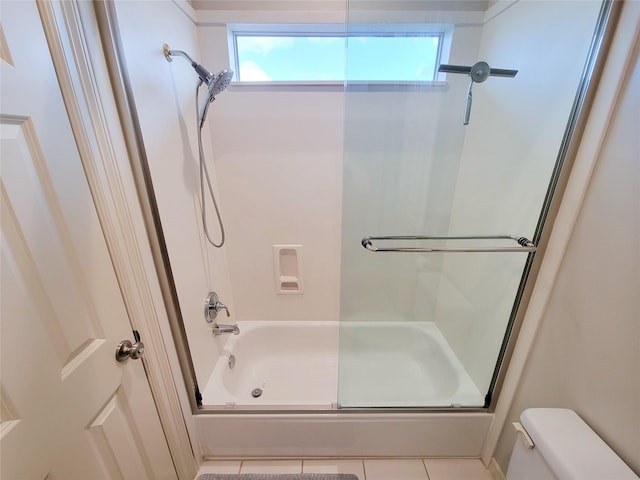 bathroom featuring tile patterned floors, shower / bath combination with glass door, and toilet