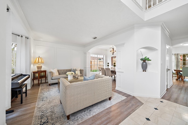 living area featuring arched walkways, a decorative wall, and a wealth of natural light