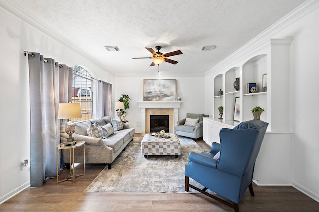 living area with visible vents, dark wood finished floors, a textured ceiling, and a tile fireplace