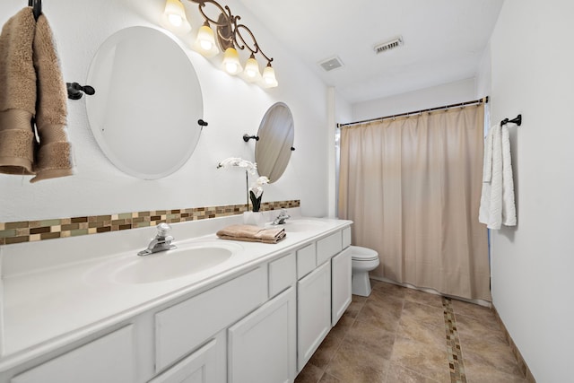 bathroom featuring visible vents, a sink, and double vanity