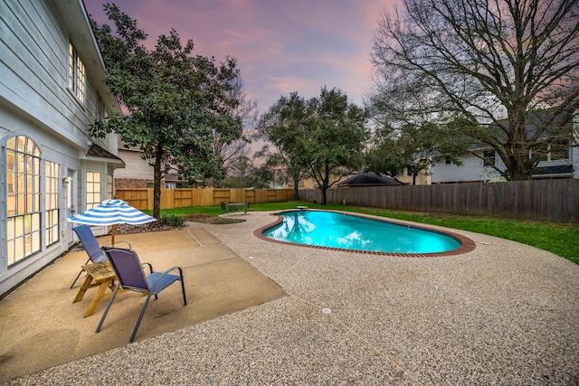 pool at dusk featuring a fenced in pool, a fenced backyard, and a patio