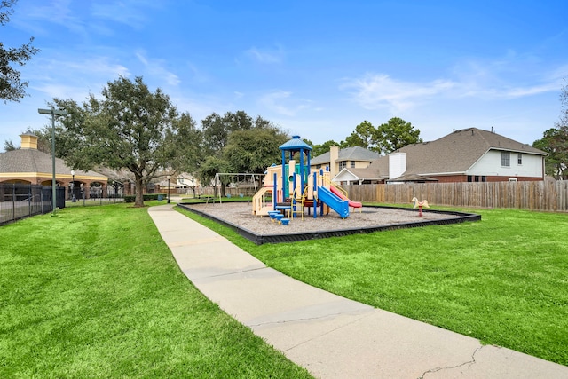 community jungle gym with a lawn and fence