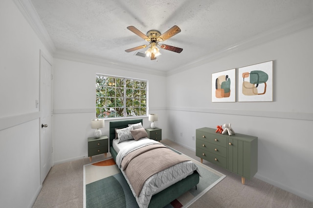 bedroom with a ceiling fan, ornamental molding, a textured ceiling, and light colored carpet