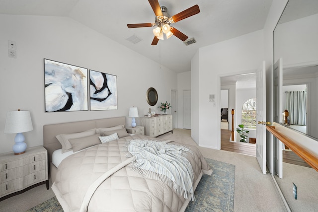 bedroom featuring light carpet, visible vents, vaulted ceiling, and a ceiling fan