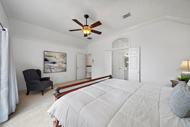 bedroom featuring ceiling fan, carpet flooring, visible vents, vaulted ceiling, and crown molding