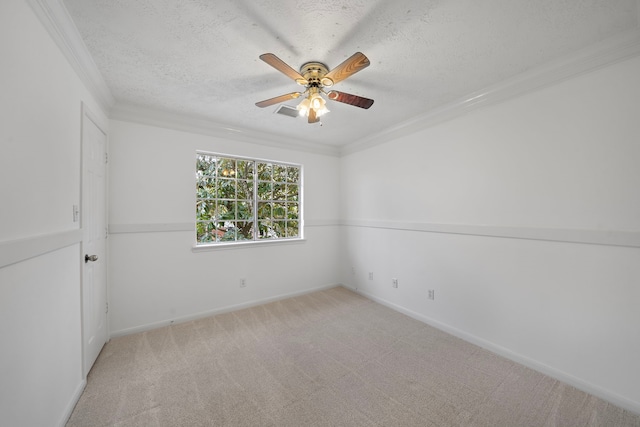 empty room featuring a textured ceiling, crown molding, a ceiling fan, and light colored carpet