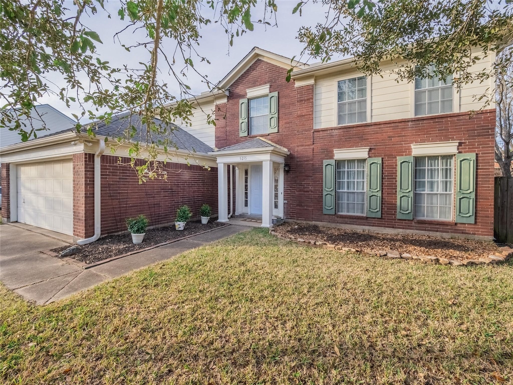 view of front of property with a garage and a front lawn