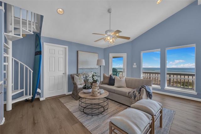 living room with vaulted ceiling, wood-type flooring, a water view, and ceiling fan