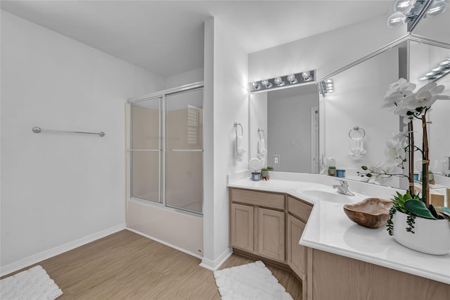 bathroom with vanity, combined bath / shower with glass door, and hardwood / wood-style floors