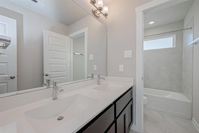 full bathroom with tiled shower / bath combo, vanity, tile patterned flooring, and toilet