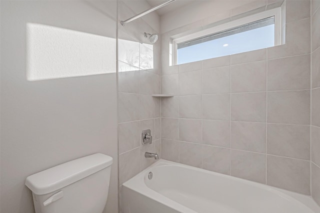 bathroom featuring toilet and tiled shower / bath combo